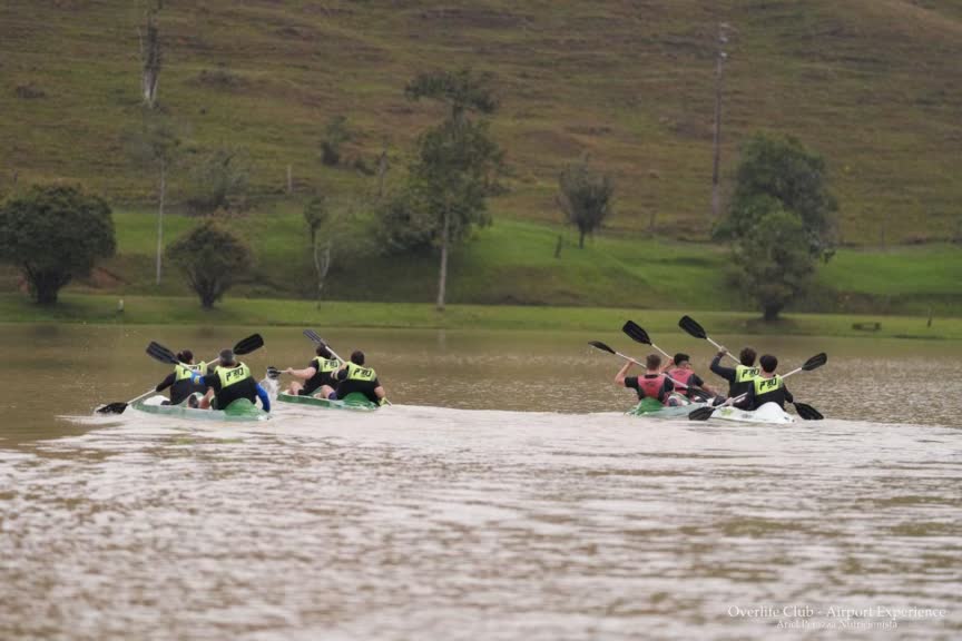 Participantes competindo no Kayak Sprint em um lago durante o evento Overlife Club Airport Experience